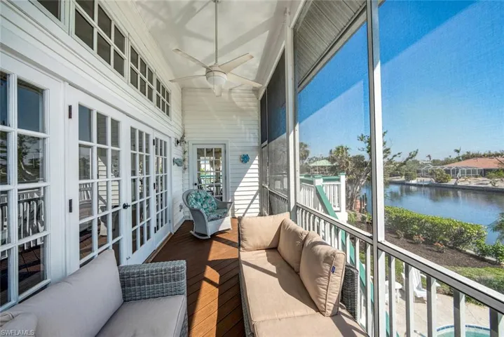 Sunroom / solarium featuring ceiling fan, a water view, plenty of natural light, and vaulted ceiling