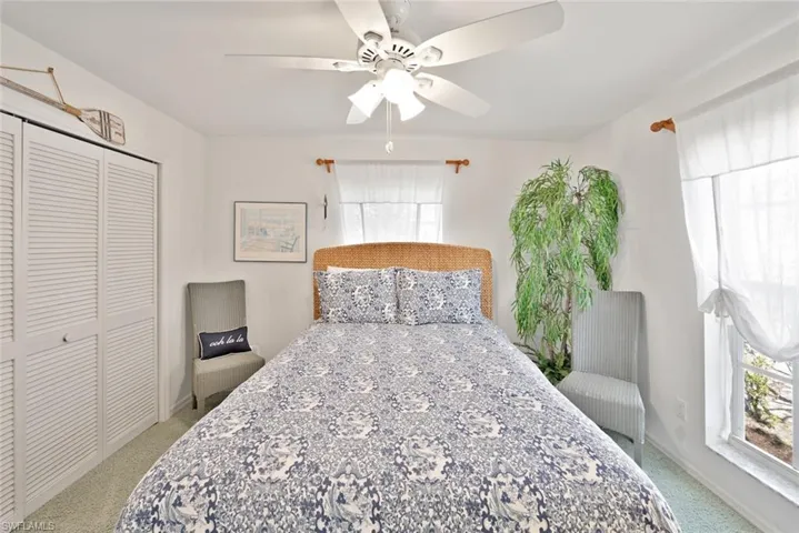 Bedroom featuring ceiling fan, light carpet, and a closet