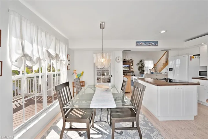 Dining space featuring a healthy amount of sunlight, a notable chandelier, and light wood-type flooring