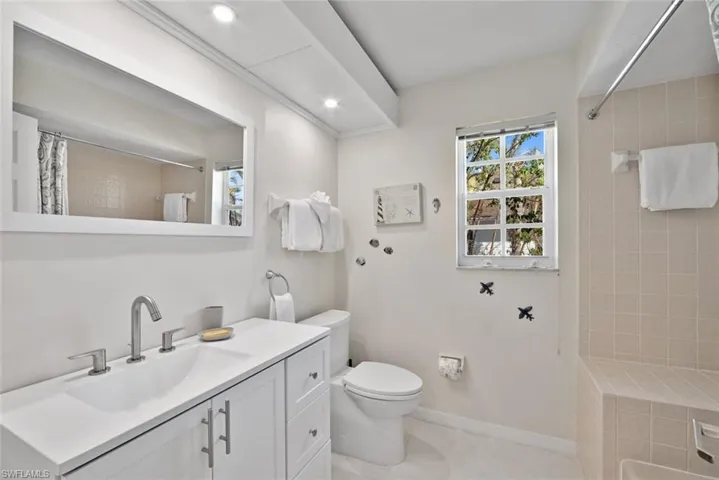 Bathroom with tile patterned floors, toilet, vanity, and walk in shower