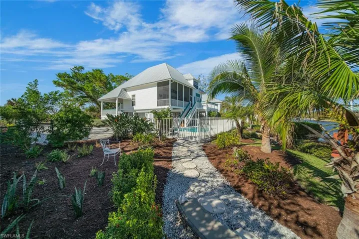 View of front facade with a fenced in pool and a sunroom