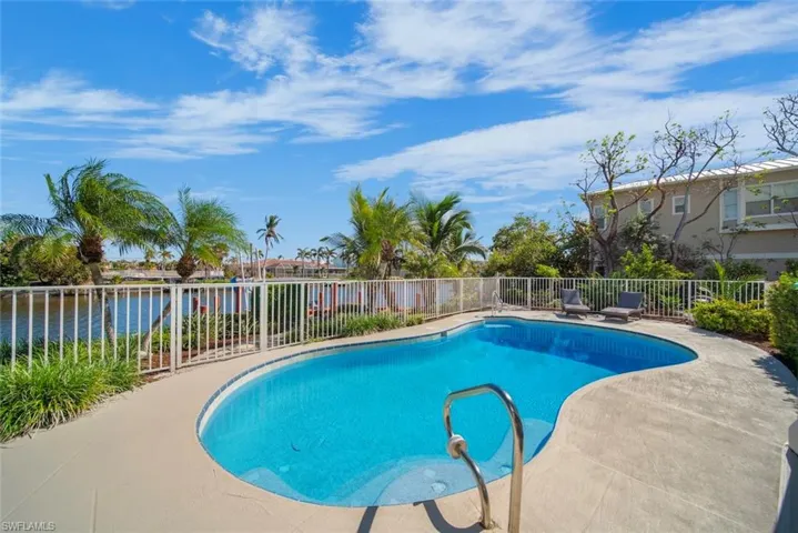 View of pool with a water view and a patio