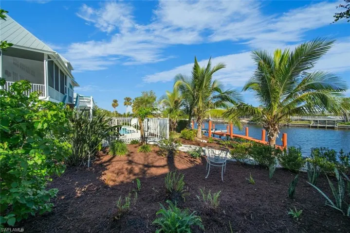 View of yard with a sunroom, a water view, and a boat dock