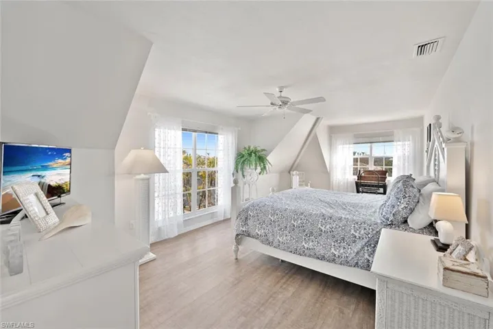 Bedroom featuring hardwood / wood-style flooring, ceiling fan, access to outside, and multiple windows