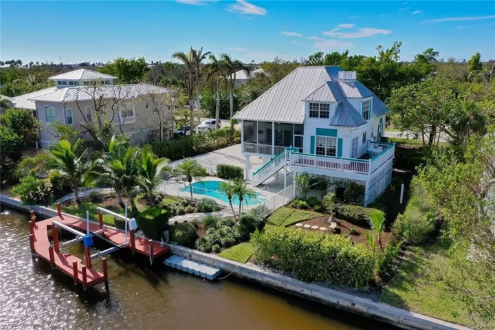 Back of house featuring a patio area, a sunroom, and a water view