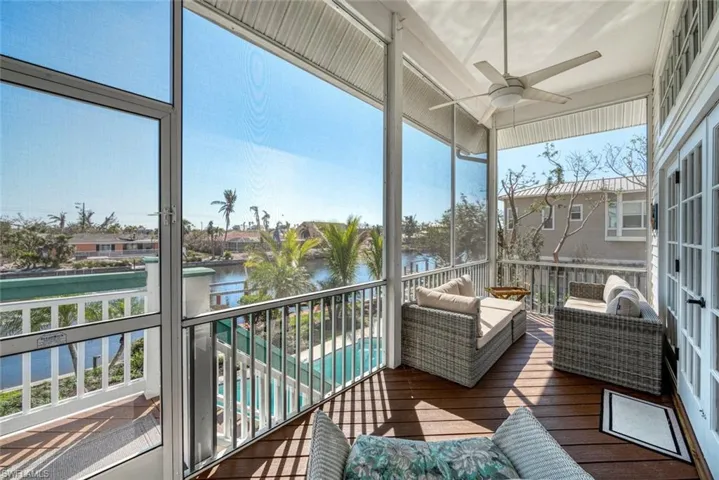 Sunroom featuring a water view, plenty of natural light, and ceiling fan