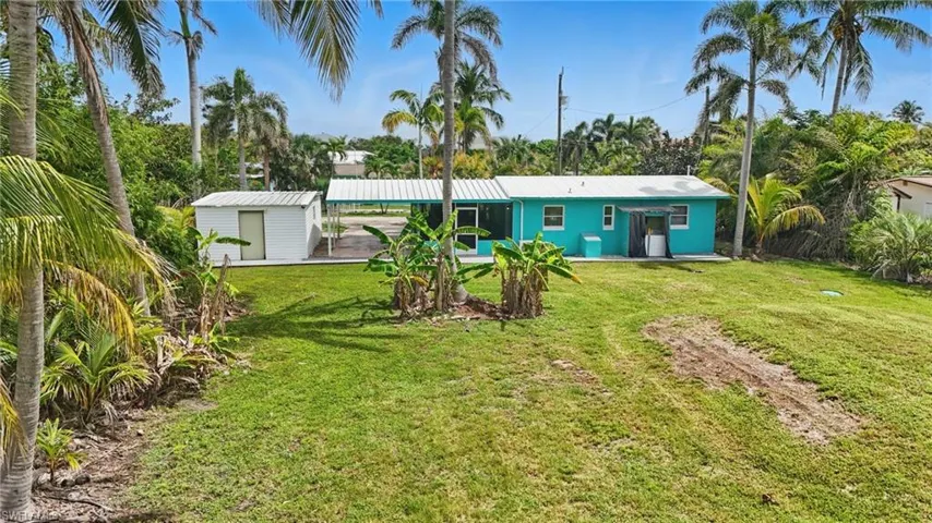 Back of house featuring a yard and a storage shed