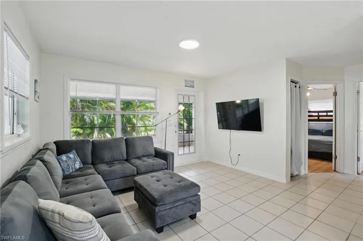 Living room with light tile patterned floors and healthy amount of natural light