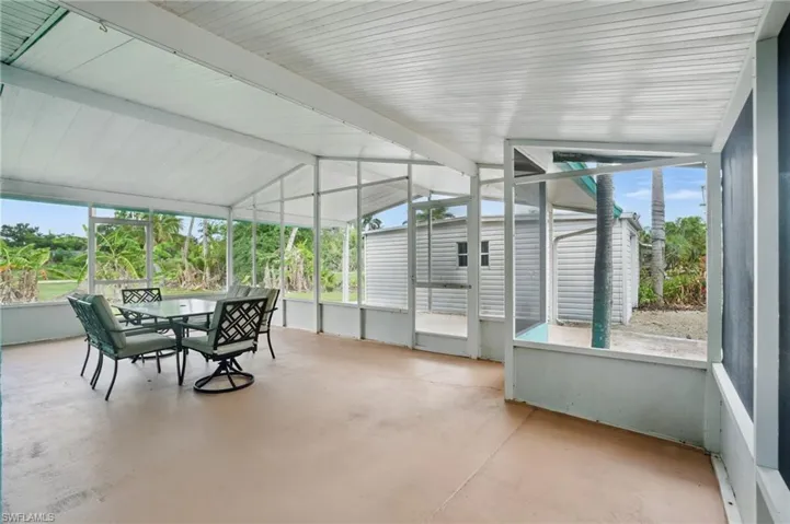 Sunroom / solarium featuring outdoor dining area, vaulted ceiling, and plenty of natural light