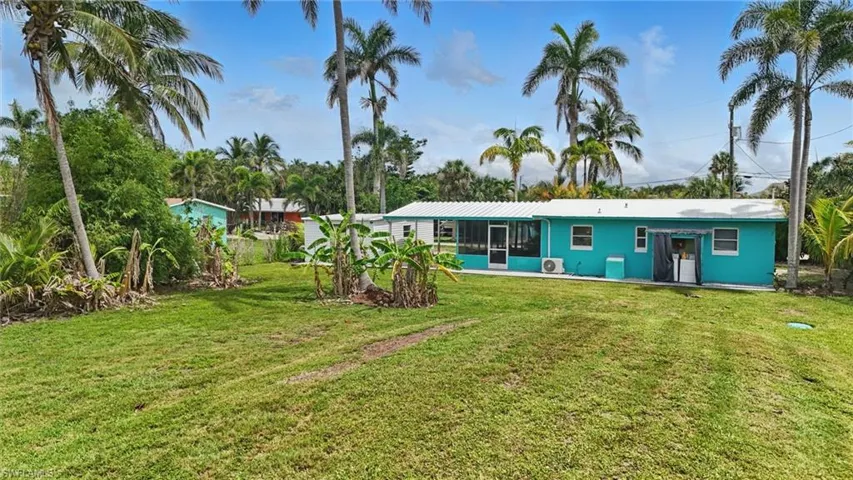 Back of property featuring a lawn and a sunroom