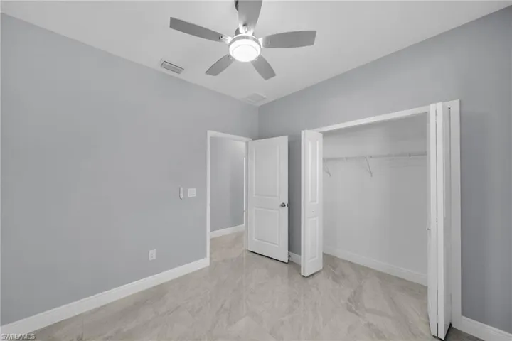 Unfurnished bedroom with a closet, ceiling fan, and baseboards