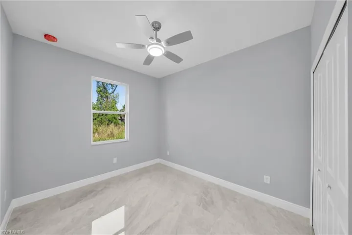 Unfurnished room featuring ceiling fan and baseboards