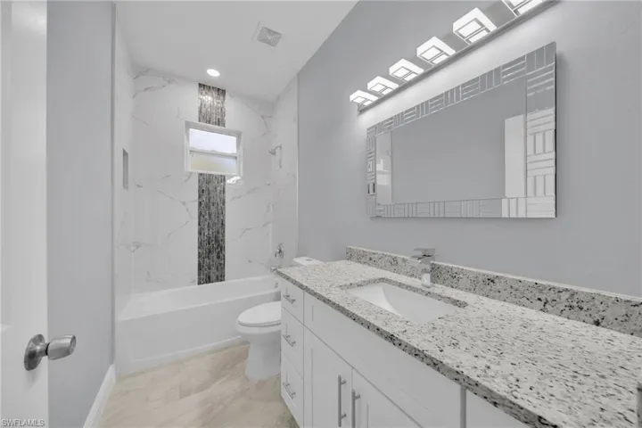 Bathroom with vanity, toilet, and bathtub / shower combination