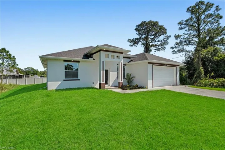 View of front of property with concrete driveway, stucco siding, a garage, and roof with shingles