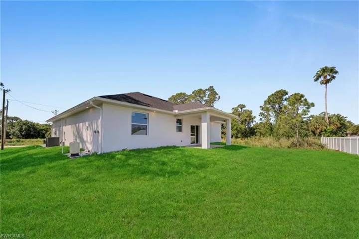 Back of property featuring central AC unit and stucco siding