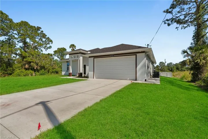 View of front facade featuring an attached garage, stucco siding, and concrete driveway