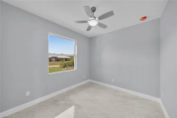 Empty room with a ceiling fan and baseboards