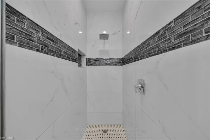 Full bathroom with a marble finish shower