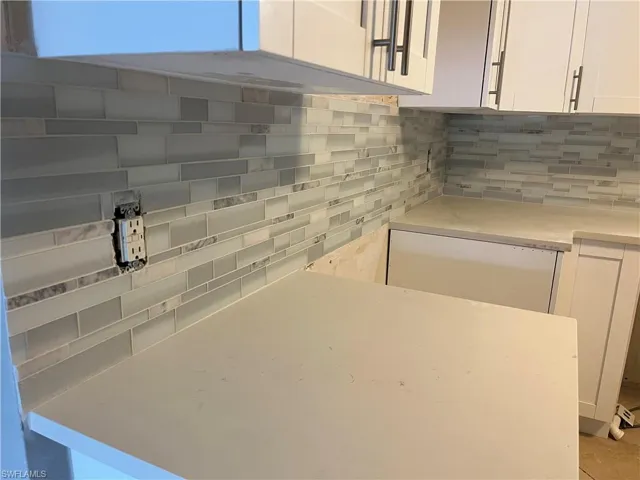 Kitchen with white cabinets and decorative backsplash