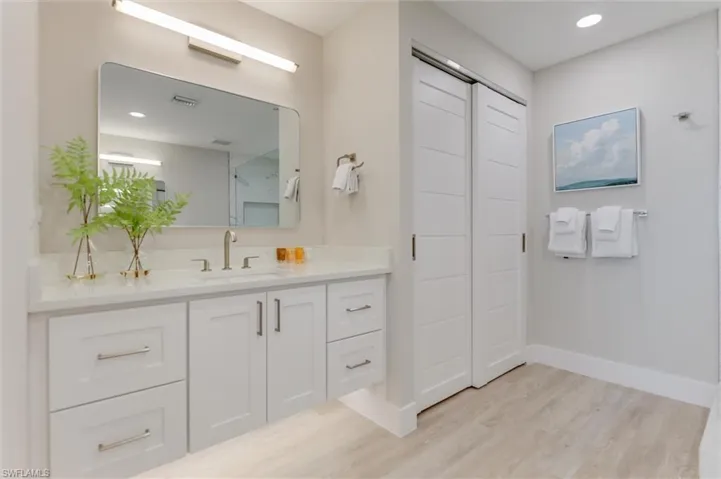 Full bath featuring vanity, light wood-type flooring, a closet, and recessed lighting