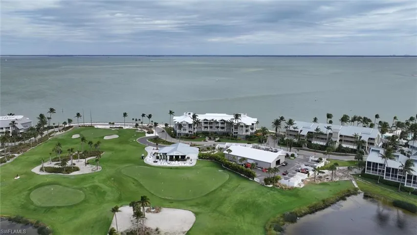 Aerial overview of property's location with a nearby body of water and a local golf course