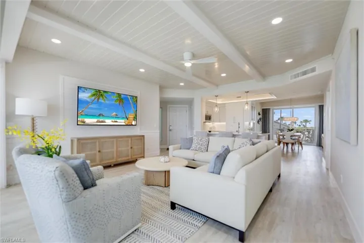 Living room featuring ceiling fan, light wood-style flooring, and a wood ceiling with exposed beams