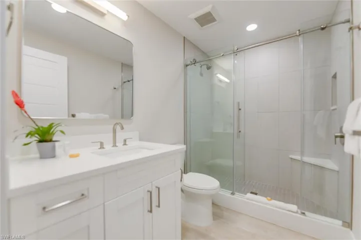 Full bathroom with vanity, a stall shower, and recessed lighting
