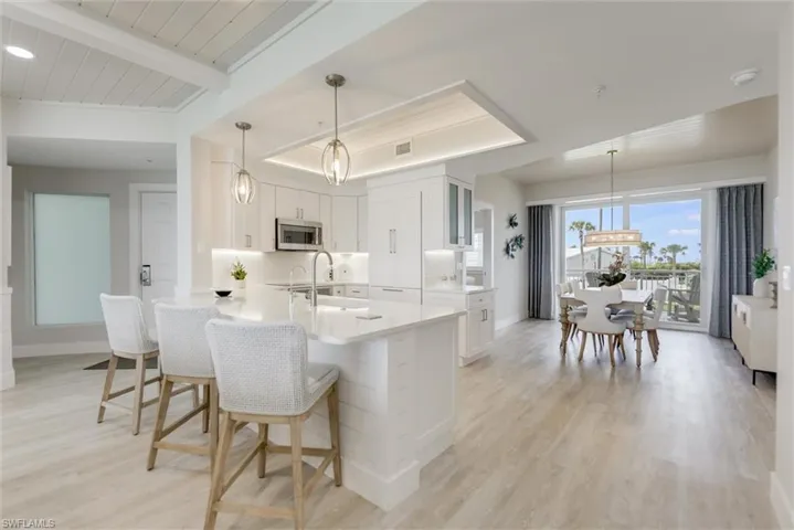Kitchen featuring hanging light fixtures, a kitchen breakfast bar, light wood finished floors, and a wood ceiling with exposed beams