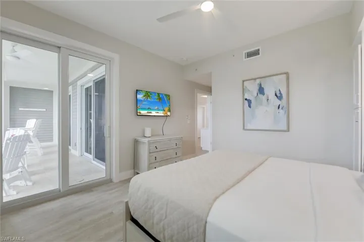 Bedroom with light wood-style floors, access to outside, and a ceiling fan