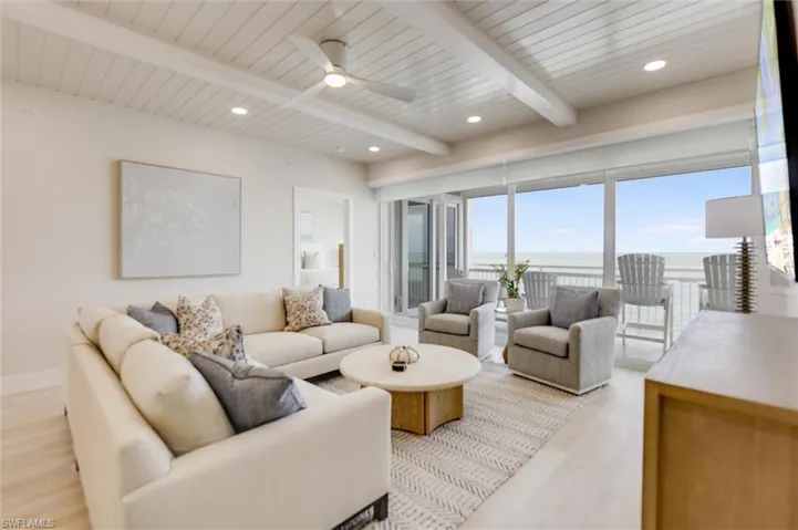 Living area with a ceiling fan, recessed lighting, light wood-type flooring, and a wooden ceiling with exposed beams