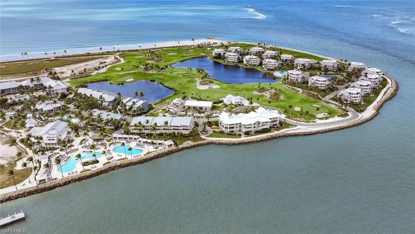 Aerial view of property and surrounding area featuring a large body of water and a pool