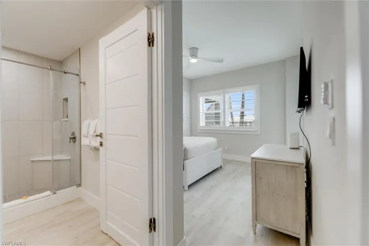 Full bathroom with a stall shower, light wood-type flooring, connected bathroom, and vanity