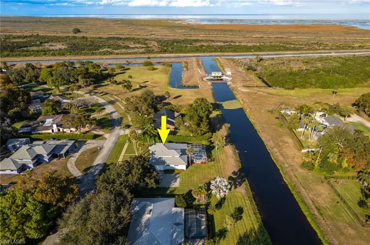 Aerial overview of property's location featuring a nearby body of water and nearby suburban area