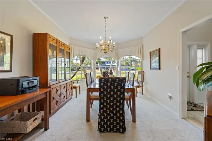 Formal dining room featuring a chandelier, and ornamental molding
