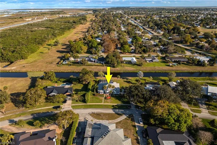 Aerial view of property's location with a large body of water and nearby suburban area