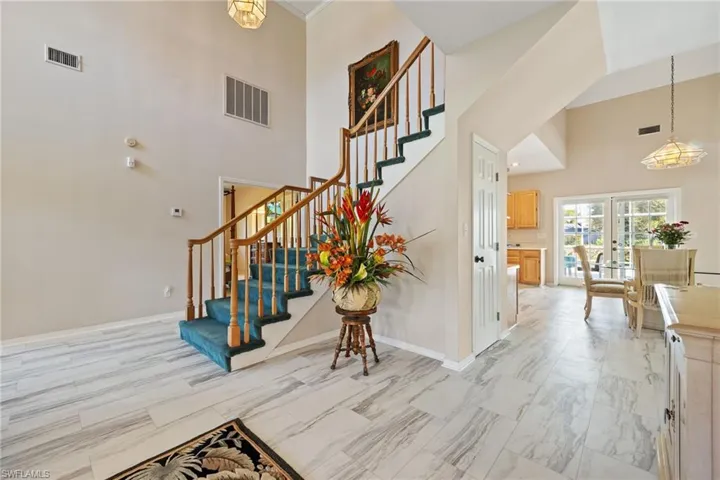 Stairway featuring a high ceiling and baseboards