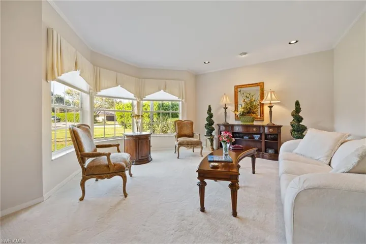 Carpeted living room featuring ornamental molding and recessed lighting