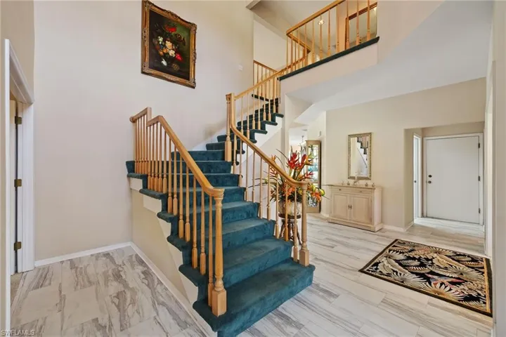 Staircase featuring baseboards and a high ceiling