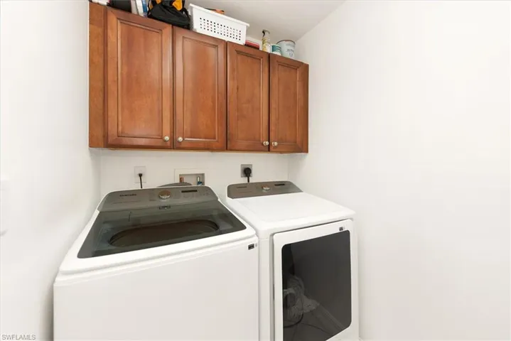 Laundry room featuring cabinet space and washer and clothes dryer