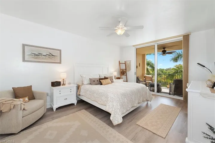 Bedroom featuring access to outside, light wood-type flooring, a ceiling fan, and expansive windows
