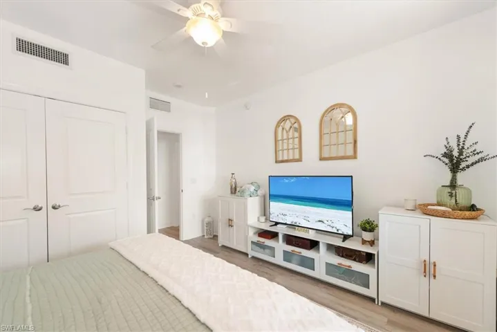 Bedroom with a closet, light wood finished floors, and a ceiling fan
