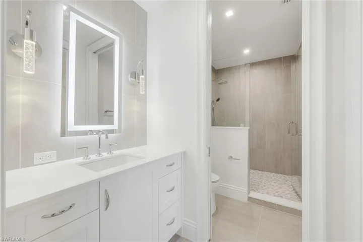 Bathroom featuring vanity, a stall shower, recessed lighting, and light tile patterned flooring