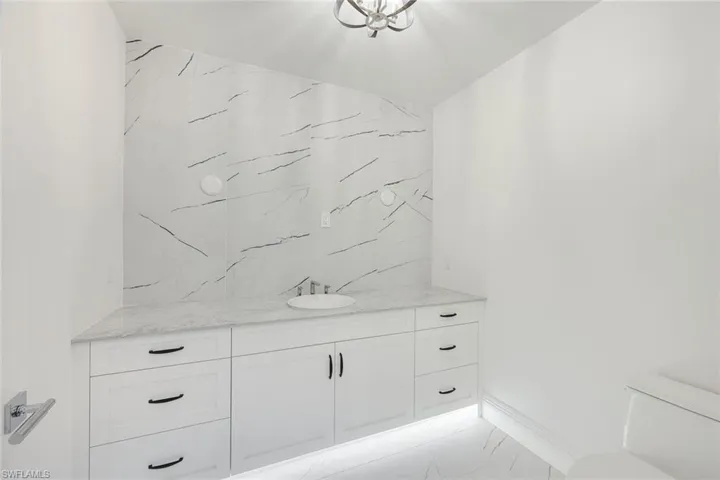 Bathroom featuring vanity and light marble finish flooring