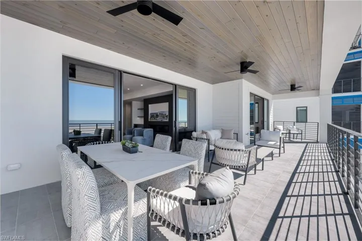 View of patio with ceiling fan, an outdoor living / dining area, and a water view