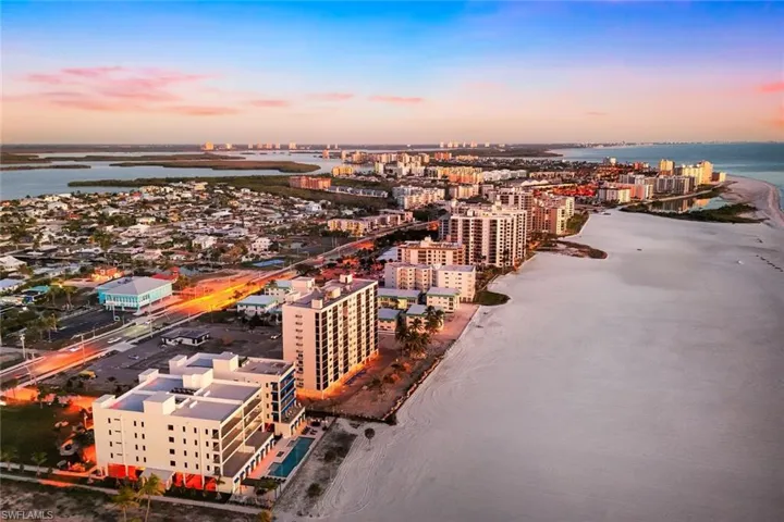 Aerial view at dusk of view of water and beach and a city view