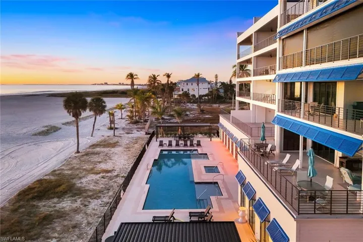 Community pool with a patio area, a water view, and outdoor dining space