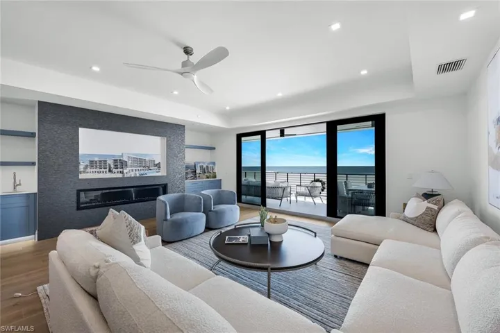 Living area featuring ceiling fan, wood finished floors, a water view, built in features, and recessed lighting