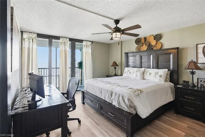 Master bedroom with ceiling fan, king bed, 2 nightstands, and a desk