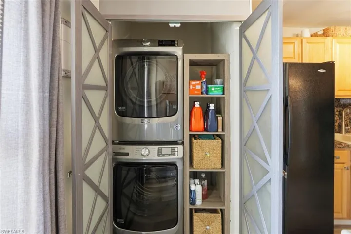 Laundry closet with stackable Maytag washer and dryer with a storage shelf.