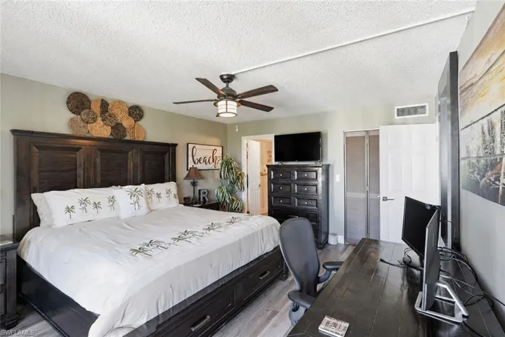 Master bedroom with ceiling fan, king bed, 2 nightstands, and a desk